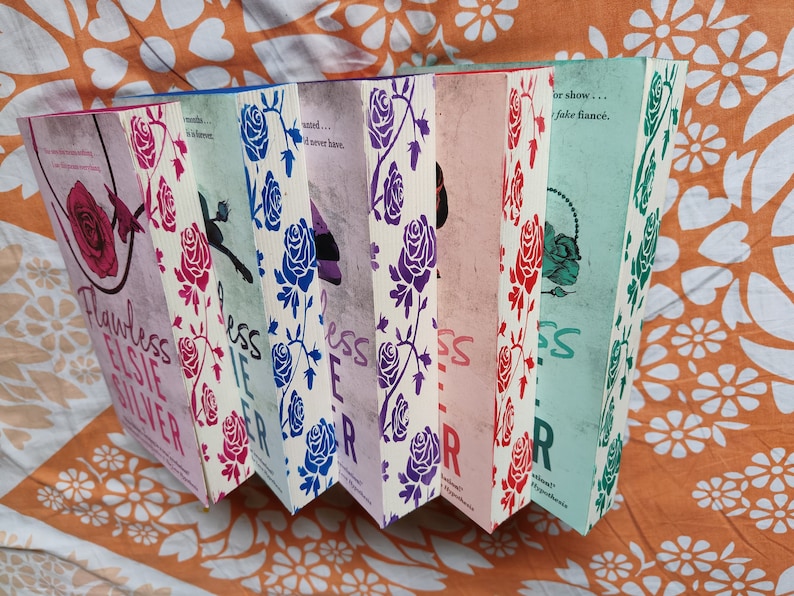 May include: A set of six paperback books with a rose pattern on the cover. The books are titled "Flawless", "Else", "Silver", "Less", "If", "Ever", and "After".