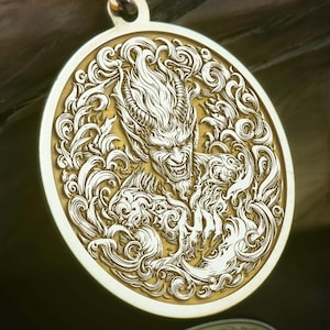 Könnte beinhalten: Goldfarbene Halskette mit Anhänger, die einen detaillierten, kreisförmigen Anhänger mit einer gravierten dämonischen Figur aufweist. Der Anhänger hängt an einer filigranen Kette. Das Design umfasst aufwendige Schnörkel und eine reflektierende Oberfläche.