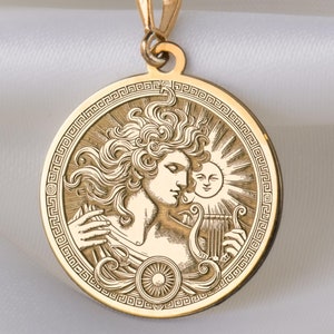 Puede incluir: Collar de oro con un colgante redondo que presenta un grabado detallado de una mujer tocando una lira con un sol detrás de ella. El colgante está rodeado por un borde decorativo.