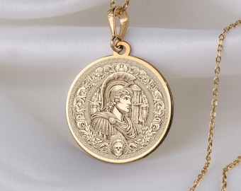 May include: A gold chain necklace with a round pendant featuring an engraved image of a warrior in a helmet. The pendant has a detailed design with a skull at the bottom.