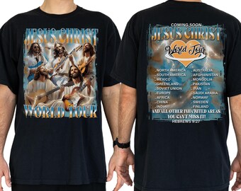 May include: Black t-shirt featuring a graphic of Jesus Christ playing guitar with the text "Jesus Christ World Tour". The back of the shirt lists tour locations. The shirt is made of a soft material.