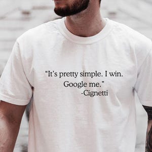 May include: White t-shirt with the quote "It's pretty simple. I win. Google me." attributed to Cignetti. The text is in black, centered on the chest. The brand name "SANGCUSTOMTEE" is printed at the bottom.