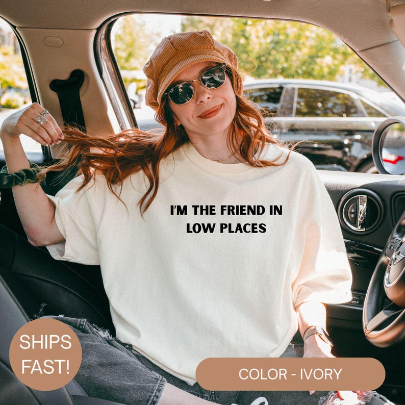 Model wearing a ivory Comfort Colors oversized t-shirt with white text reading “I’m the Friend in Low Places,” relaxed casual fit