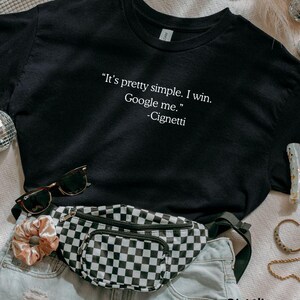 May include: Black t-shirt with the quote "It's pretty simple. I win. Google me." by Cignetti. The shirt is paired with a checkered fanny pack, sunglasses, and denim shorts. The text "BLACK SANGCUSTOMTEE" is also visible.