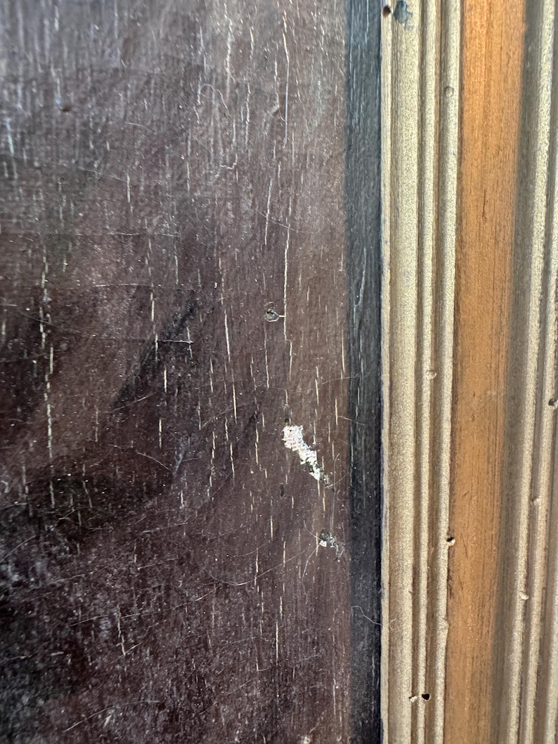 Op de afbeelding: Close-up van een deel van een houten frame. De linkerkant is een donkerbruin, verweerd hout met witte strepen. De rechterkant is een lichtbruin, geribbeld hout met verticale lijnen.