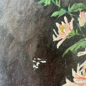 Op de afbeelding: Een antiek bloemenschilderij met lichtroze en witte bloemen met gele centra en groene bladeren tegen een donkere achtergrond. Het kunstwerk heeft zichtbare penseelstreken en een textuur, wat wijst op een olieverfschilderij.