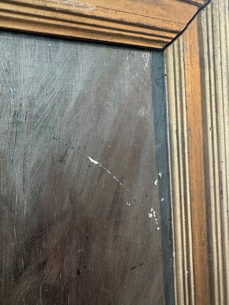 Op de afbeelding: Close-up van een schilderij met een donkere, getextureerde achtergrond. Het schilderij is ingelijst in een goudkleurige houten lijst met een geribbeld ontwerp. Het kunstwerk heeft zichtbare penseelstreken en witte verfspatten.