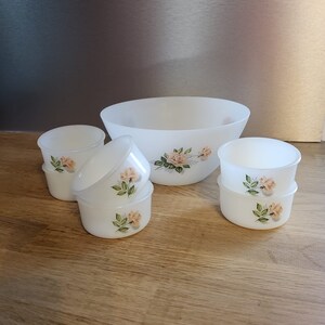 Puede incluir: Un juego de seis cuencos de cerámica blanca con un diseño floral. Los cuencos son de varios tamaños, siendo el más grande un cuenco para ensaladas. Los cuencos tienen un delicado patrón floral con rosas rosas y hojas verdes.