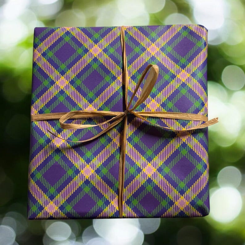 Op de afbeelding: Paars, groen en geel geruit cadeaupapier met een gouden lint gebonden in een strik.