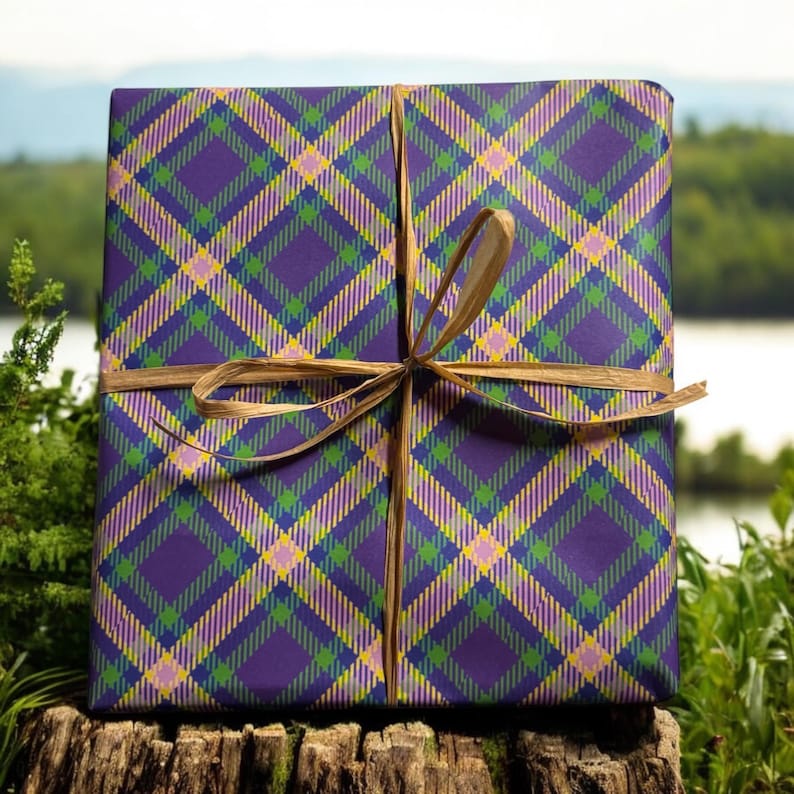 Op de afbeelding: Een paarse, groene en gele geruite cadeaudoos gebonden met een bruin lint.