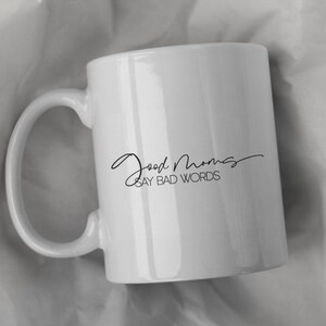 May include: White ceramic coffee mug with black text that reads "Good Mornings Say Bad Words".