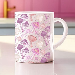 May include: White ceramic mug with a pink and purple mushroom pattern. The mushrooms are drawn in a whimsical style with pink and purple accents.
