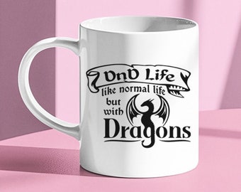 May include: White ceramic mug with a black design that says "Dnd Life like normal life but with Dragons". The design includes a black dragon with wings.