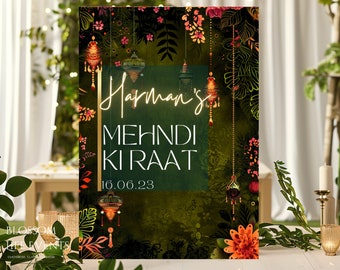 May include: A green and gold sign with the text "Harman's Mehndi Ki Raat 16.06.23" in white lettering. The sign is decorated with floral patterns and hanging lanterns.