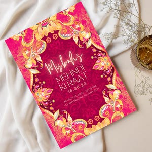 May include: A pink and gold invitation with intricate floral designs. The text reads "Misbah's Mehndi Kiraat 16.06.23 March 13, 2022 - 12:00 PM 123 Anywhere St. Any City"
