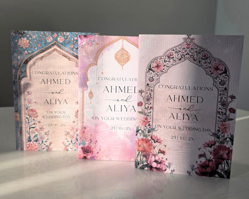 May include: Three rectangular wedding cards featuring an arched frame design with floral accents. Each card displays the text CONGRATULATIONS AHMED and ALIYA ON YOUR WEDDING DAY 25 | 10 | 2X. The cards feature blue, pink, and light purple color palettes.