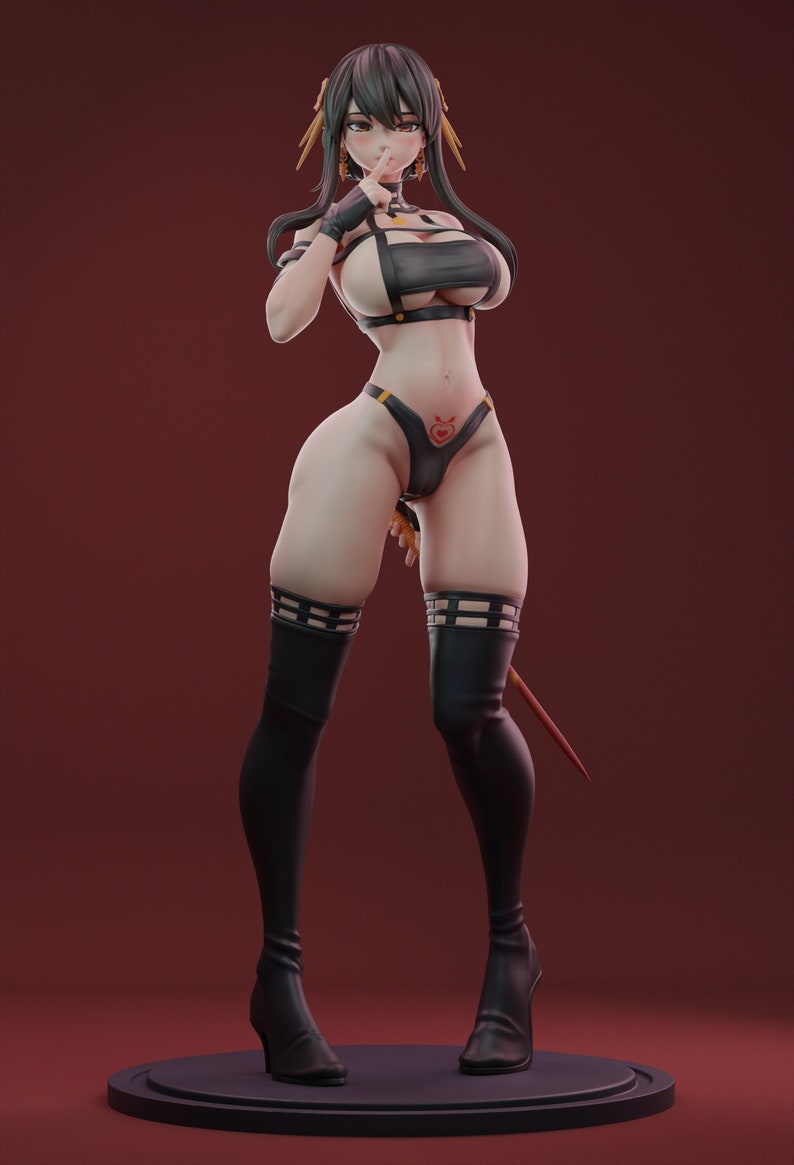 May include: A black and gold figure of a woman with long black hair, wearing a black and gold outfit with a heart-shaped tattoo on her stomach. She is holding her finger to her lips, as if to tell someone to be quiet.