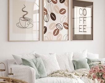 Pode incluir: Três impressões emolduradas com um tema de café. A primeira impressão apresenta um desenho de linha de uma xícara de café com vapor saindo dela. A segunda impressão apresenta um padrão de grãos de café marrons e bege. A terceira impressão apresenta a palavra "COFFEE" em texto preto sobre um fundo marrom.