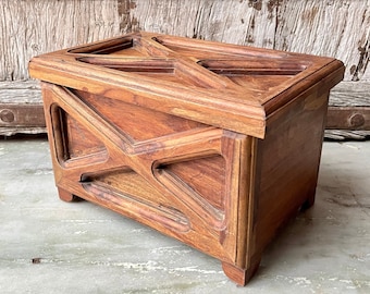 May include: A wooden box with a geometric design on the front. The box is made of dark wood and has a natural finish.