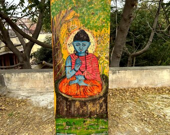 May include: A wooden panel with a painted image of a blue Buddha sitting in a lotus position. The Buddha is wearing a red robe and has a halo around his head. The background is a yellow and green landscape with trees and a moon.