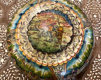 May include: A round, decorative box featuring a painted scene of an elephant and a tiger in a forest. The box is crafted from wood and boasts a colourful, intricate design.