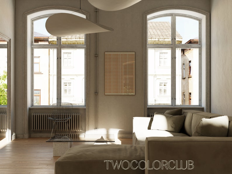 May include: A living room with two large windows, a brown couch, a coffee table, and a chair. The walls are a light beige color and there is a framed print on the wall.