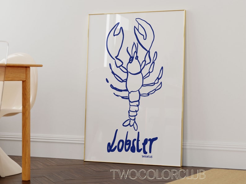 K&ouml;nnte beinhalten: Ein wei&szlig;er gerahmter Poster mit einer blauen Linienzeichnung eines Hummers. Der Poster hat das Wort "Lobster" in blau unter der Zeichnung und den Text "TWOCOLORCLUB" in kleineren blauen Buchstaben unter dem Wort "Lobster" geschrieben.