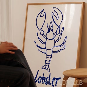 K&ouml;nnte beinhalten: Eine gerahmte Illustration eines blauen Hummers mit dem Wort "Lobster" darunter.