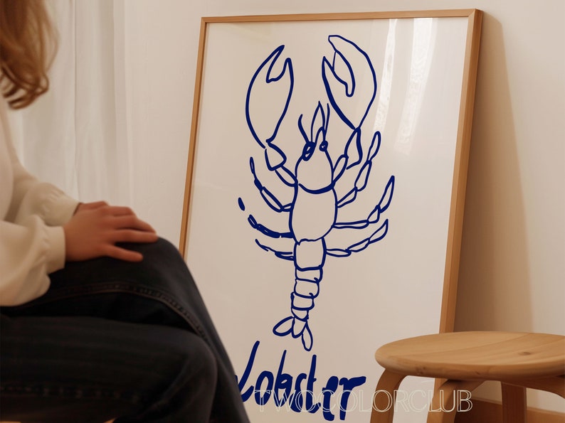 K&ouml;nnte beinhalten: Eine gerahmte Illustration eines blauen Hummers mit dem Wort "Lobster" darunter.