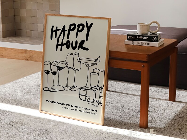 May include: A framed print with the text "HAPPY HOUR" in black lettering. The print features a black and white illustration of various glasses of wine and cocktails. The text "WEEK NIGHTS 6 PM - 11:30 PM" and "SHOULD WE GET ANOTHER DRINK?" is also included on the print.