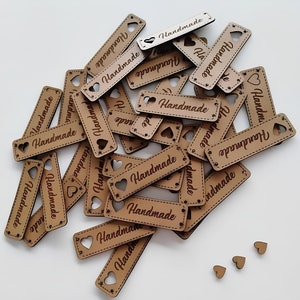 May include: A pile of brown wooden tags with the word "Handmade" engraved on them. Each tag has a heart-shaped cutout.