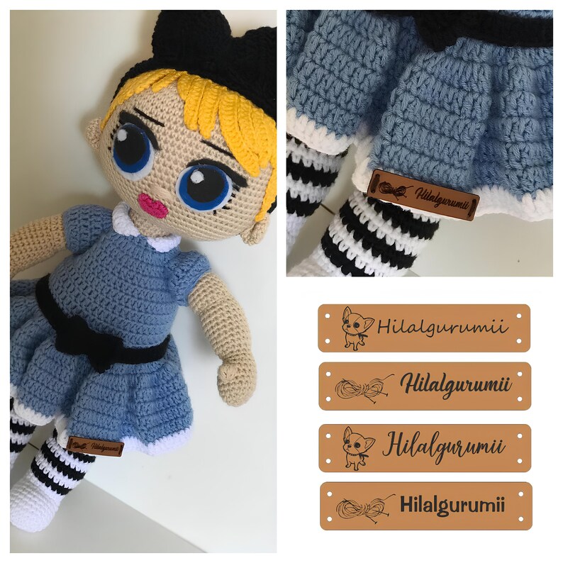 May include: A crocheted doll with blonde hair, blue eyes, and a blue dress with a black bow. The doll is wearing black and white striped stockings and a black headband with a bow. The doll is holding a brown leather tag with the text "Hilalgurumii".