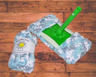 May include: A green dust mop with a blue and white fluffy cover. The cover is made of 100% cotton and is labeled "Dust Mop Cover" with a sun graphic.