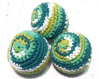 May include: Three crocheted balls in shades of green, white, and blue. The balls are made with a textured stitch and have a swirling pattern.