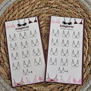 Op de afbeelding: Twee rechthoekige kaarten met een bordeauxrode rand en het woord "Lingerie" bovenaan. Elke kaart heeft een raster van bh-illustraties en de tekst "Savings challenge". De kaarten liggen op een geweven, cirkelvormig oppervlak.