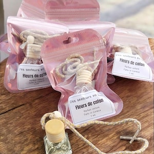 Peut inclure: Quatre sachets en plastique rose avec fermeture éclair contenant des diffuseurs d'air pour voiture. Chaque sachet porte une étiquette blanche avec le texte "Des senteurs en Fleurs de coton Parfum voiture Fattu in Corsica 7 MI".
