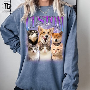 May include: A blue sweatshirt with the text "CUSTOM Your Pet" in a purple and white gradient. The sweatshirt features a collage of five animals: a corgi, a husky, a Shiba Inu, and two cats.
