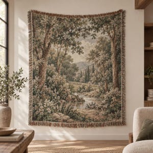 May include: A rectangular woven wall tapestry featuring a landscape scene with a flowing stream, lush green trees, and distant mountains. The textile has a fringed border in muted earth tones, depicting a serene forest clearing with foliage.