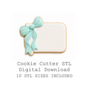 May include: A cookie cutter in the shape of a rectangular tag with a light blue bow. The cookie cutter is white with a light brown border. The text "Cookie Cutter STL Digital Download 10 STL SIZES INCLUDED" is below the cookie cutter.