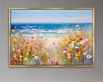 May include: A rectangular landscape painting in a gold frame depicting a coastal scene. The foreground features a dense field of wildflowers in shades of pink, yellow, white, and orange. In the background, blue ocean waves meet a sandy beach.
