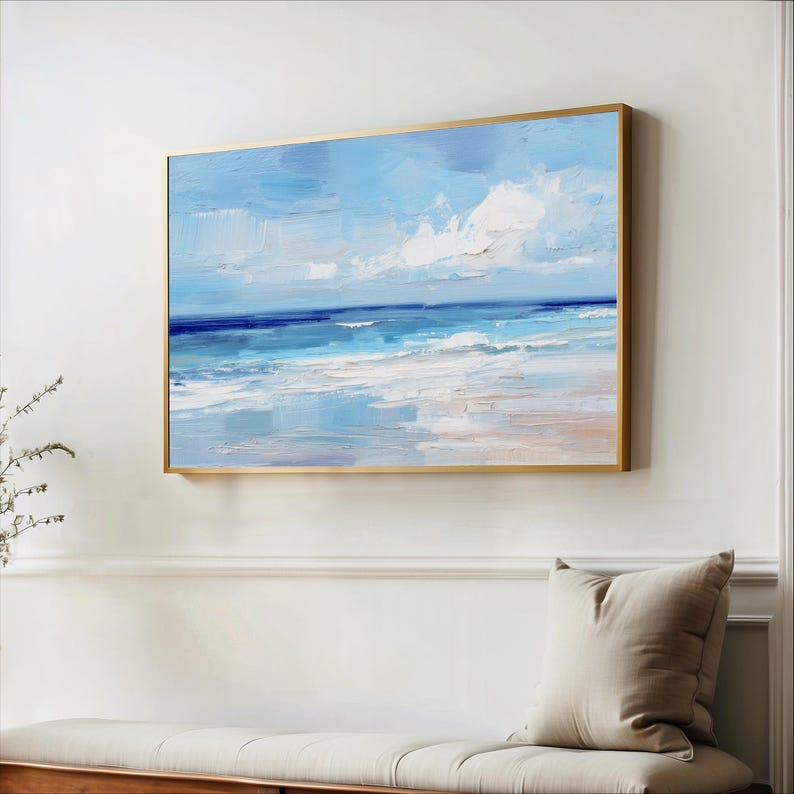 a large painting of a serene ocean scene hanging on a white wall above a wooden bench.