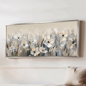 May include: A rectangular wall art piece featuring an abstract floral painting in a silver frame. The artwork displays white and cream-colored flowers with dark centers, set against a soft beige background with muted gray and blue brushstrokes.