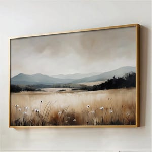Puede incluir: Pintura de paisaje enmarcada en un marco dorado. Representa un campo de hierba alta y flores silvestres en primer plano, con montañas y un cielo nublado al fondo. La obra evoca una sensación de serenidad.