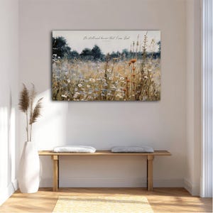 a serene indoor setting with a wooden bench, a white vase, and a painting of a field of flowers hanging on the wall.