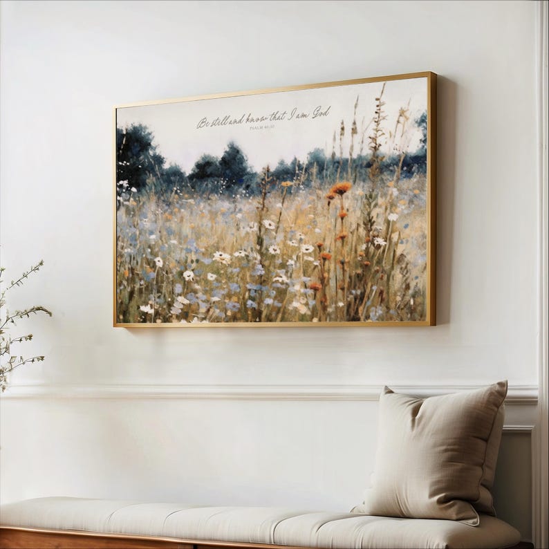 a painting of a field with flowers hanging on a wall.