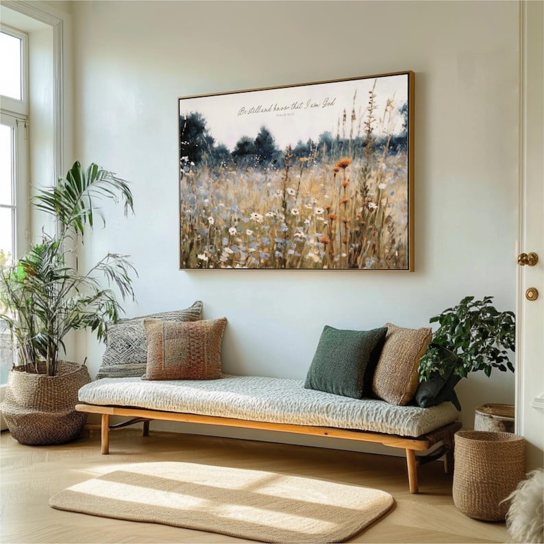 a living room with a large painting of a field of flowers hanging on the wall above a wooden bench with pillows. The room is decorated with potted plants and a rug, creating a cozy and inviting atmosphere.