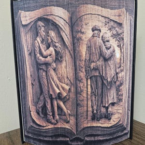 Puede incluir: Escultura de libro plegado con lomo negro y páginas talladas con escenas románticas. Un lado representa a una pareja bailando, el otro a una pareja de ancianos caminando. Las páginas están intrincadamente cortadas.