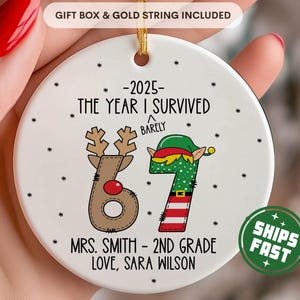 May include: A white ceramic ornament with a gold string, featuring the text "-2025- THE YEAR I SURVIVED BARELY" and a reindeer-themed "6" and an elf-themed "7". The ornament also includes the text "MRS. SMITH - 2ND GRADE LOVE, SARA WILSON".