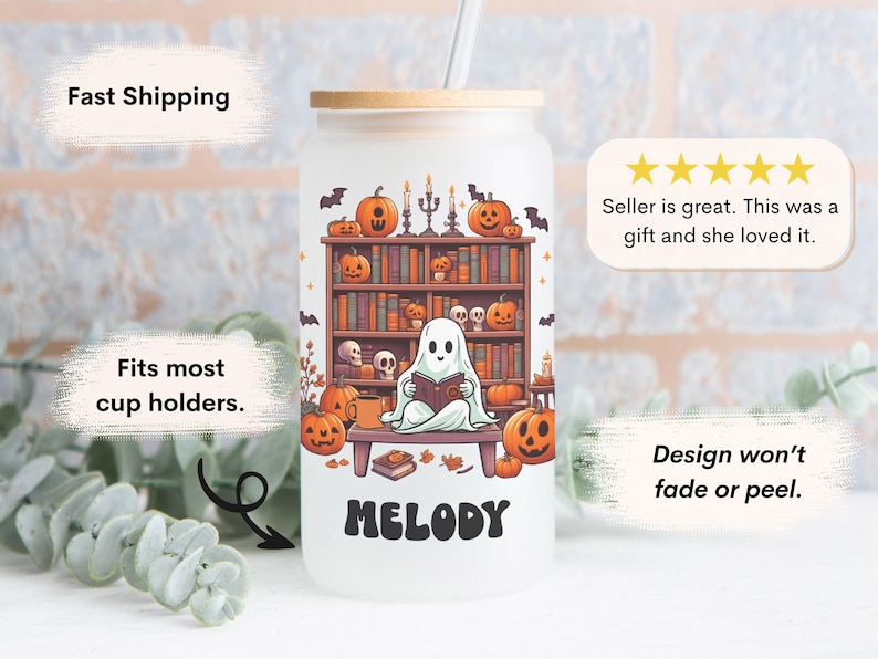 May include: A white reusable tumbler with a ghost reading a book in front of a bookshelf with pumpkins and bats. The tumbler has a bamboo lid and a straw. The text "MELODY" is printed on the front of the tumbler.