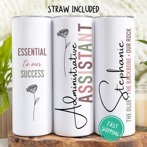 May include: Three white tumblers with black text and floral designs. The tumblers read "Essential to our Success", "Administrative Assistant", and "Stephanie - The Glue - The Backbone - Our Rock".